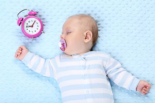 bébé qui dort avec un réveil